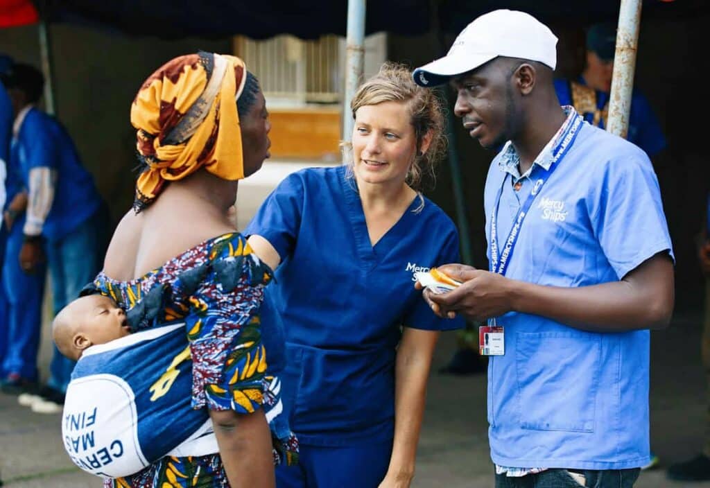 Mirjam Hamer, Screening Nurse, talking to a potential patient at the mass screening at Palais du Peuple. © Mercy Ships