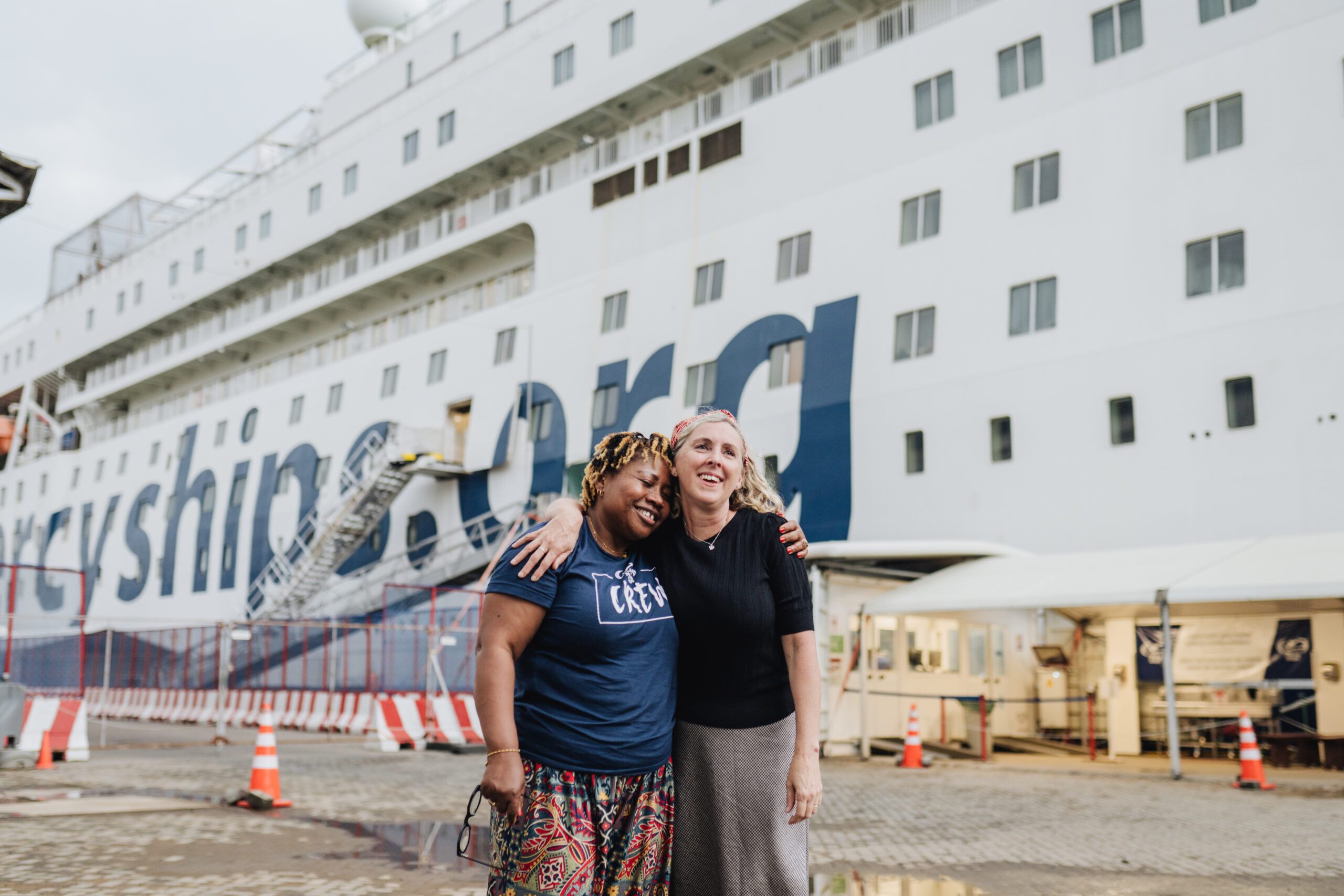 Aly Hall and Catherine Conteh together in front of the Global Mercy after not seeing each other for 30 years.