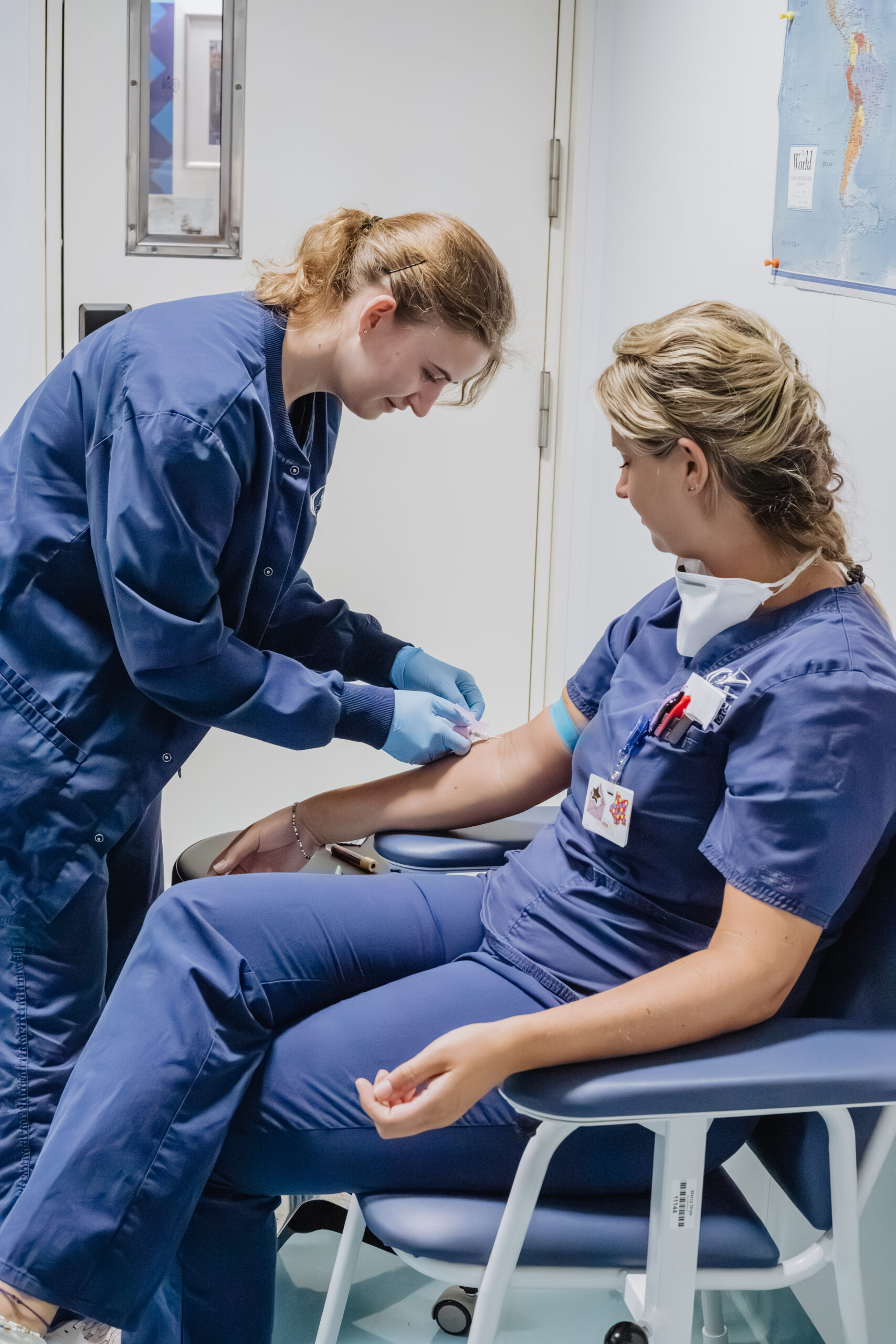 Breanna Charleson, Laboratory Technologist, drawing Esther Flier, Ward Nurse, blood.